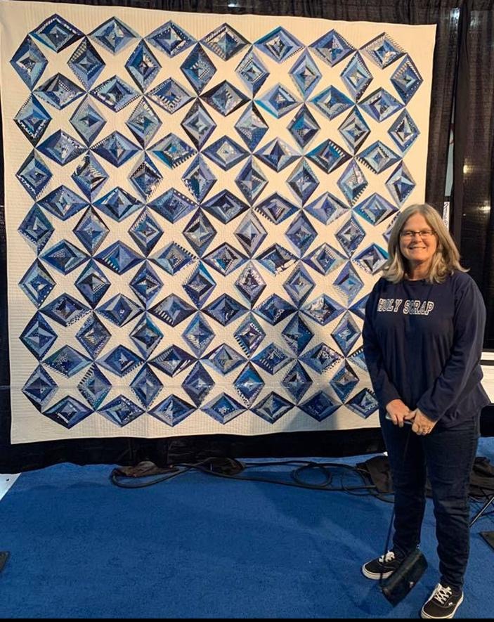 Stunning blue and white diamond star pattern displayed at a quilt show